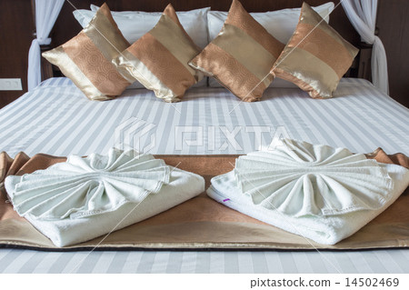 Close up of nice towels on white bed sheet 14502469