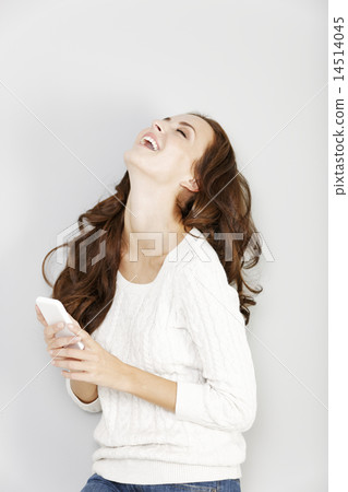 Woman laughing at her phone Woman laughing at her phone 14514045