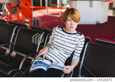 woman reading newspaper at Charles de Gaulle airport, 14516871