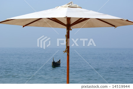 Parasol on a sandy beach. Ocean. 14519944