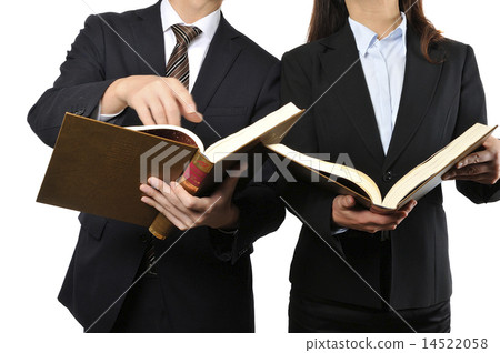 A male and female businessman reading a thick book A male and female businessman reading a thick book 14522058