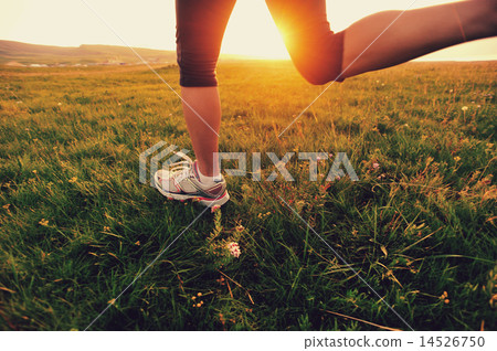Runner athlete running on grass seaside.  14526750