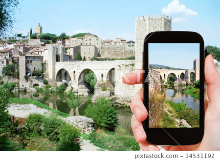 tourist shoots photo of bridge in Besalu town 14531192