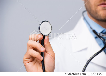 Male doctor holding stethoscope Male doctor holding stethoscope 14531350