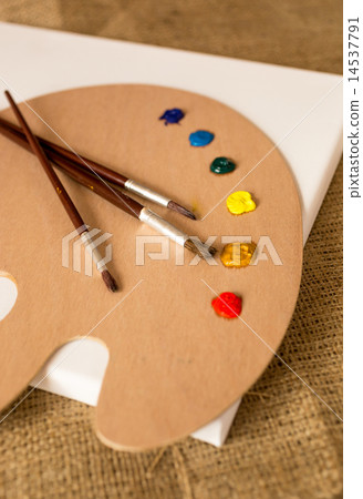 paintbrushes lying on wooden pallet with oil paint blobs paintbrushes lying on wooden pallet with oil paint blobs 14537791
