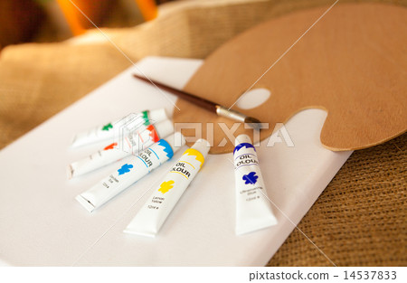pallet and oil paint tubes lying on white canvas pallet and oil paint tubes lying on white canvas 14537833