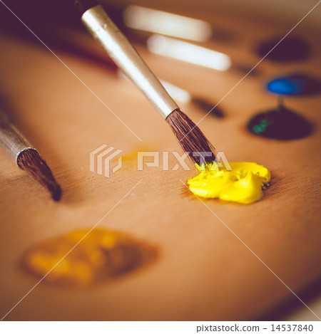 toned photo of paintbrush dipping in vivid yellow oil paint toned photo of paintbrush dipping in vivid yellow oil paint 14537840