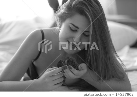 monochrome portrait cute woman lying in bed and holding rose 14537902
