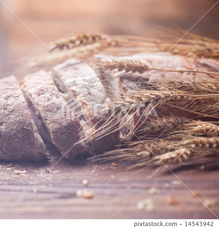 Bread and wheat on wooden table, shallow DOF Bread and wheat on wooden table, shallow DOF 14543942