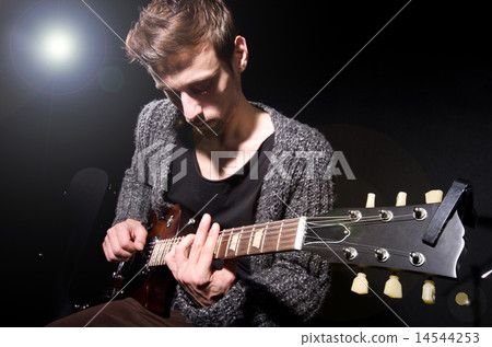 Man playing guitar during concert 14544253