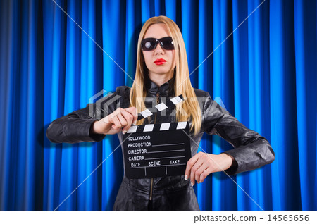 Girl with movie board against curtains Girl with movie board against curtains 14565656