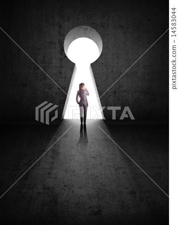businesswoman against black wall with key hole 14583044