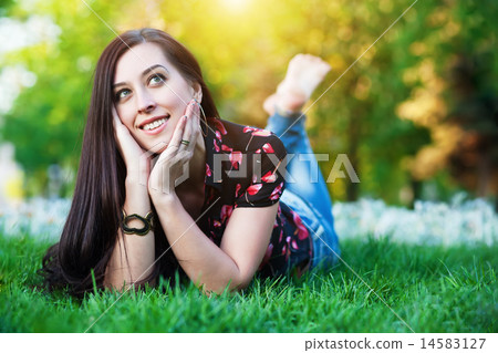 happy pretty girl laying on the grass happy pretty girl laying on the grass 14583127