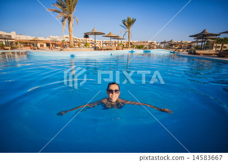 Woman swimming in a blue swimming pool Woman swimming in a blue swimming pool 14583667