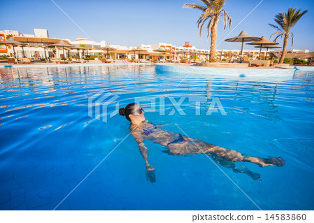 Woman swimming in a blue swimming pool Woman swimming in a blue swimming pool 14583860