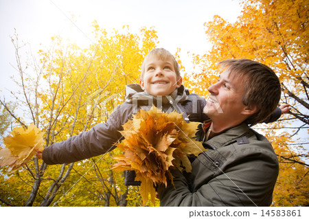 dad and son are playing in a yellow autumn park dad and son are playing in a yellow autumn park 14583861