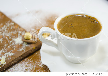 White cup of coffee and a chocolate 14584736