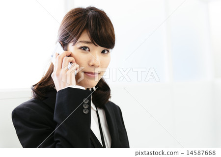 A woman in a suit wearing a phone call 14587668