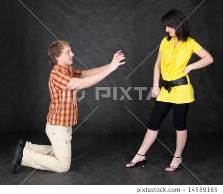 Man is kneeling to the young woman 14589165