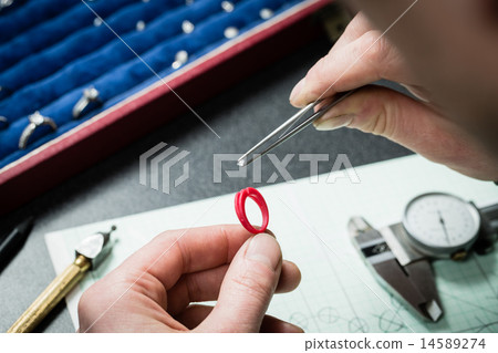 Jeweler working with wax model ring 14589274