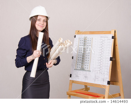 Woman builder in helmet standing with drawings 14614493