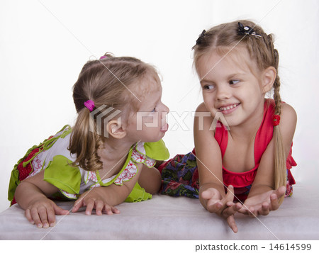 Two girls lie, one tongue, the other smiles 14614599