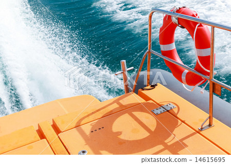 Red lifebuoy hanging on railings of rescue boat 14615695