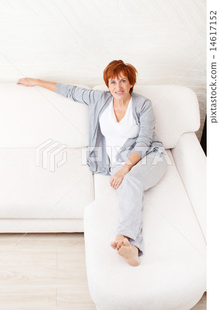 Happy mature woman on sofa Happy mature woman on sofa 14617152