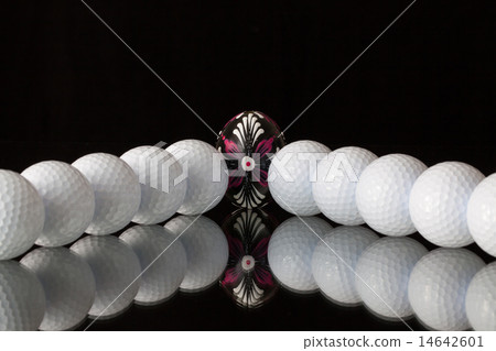 Golf balls and egg on a black glass desk Golf balls and egg on a black glass desk 14642601