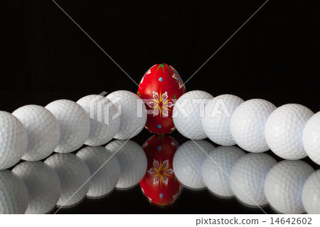 Golf balls and egg on a black glass desk Golf balls and egg on a black glass desk 14642602
