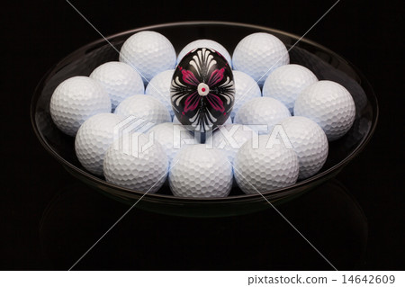 Golf balls and egg on a black plate Golf balls and egg on a black plate 14642609
