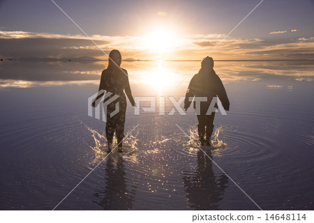 Women in Uyuni salt lake evening view of Mirror Lake Women in Uyuni salt lake evening view of Mirror Lake 14648114