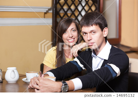 Young couple sit near table in coffee shop. 14695132