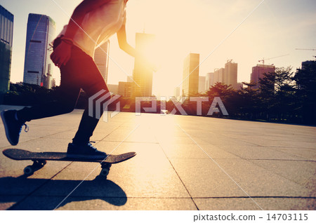 woman skateboarder legs skateboarding at sunrise c 14703115