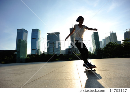 woman skateboarder legs skateboarding at sunrise c 14703117