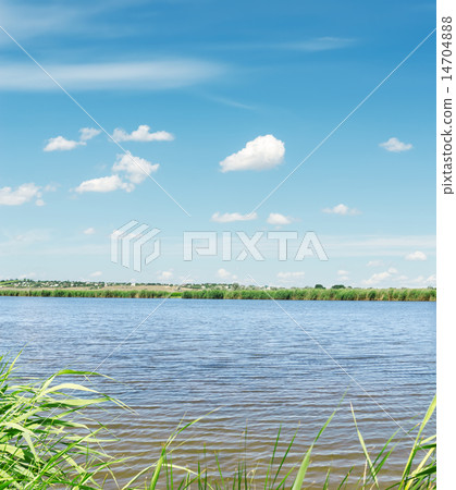 river with green coast and clouds in blue sky 14704888