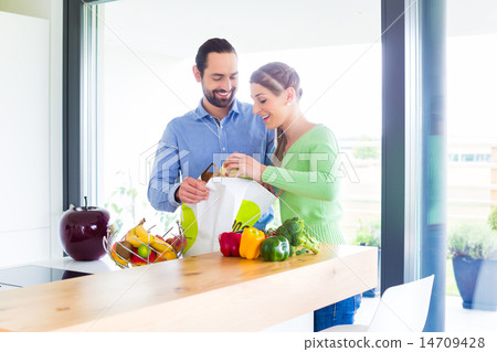 Couple unpacking grocery shopping bag at home 14709428