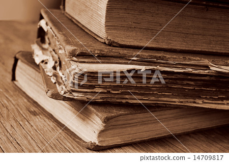 old books on a rustic wooden table, sepia toning 14709817