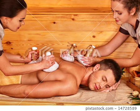 Man getting herbal ball massage treatments . Man getting herbal ball massage treatments . 14728589