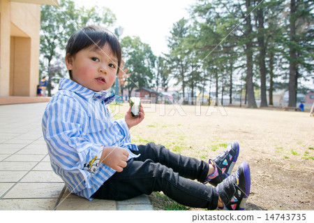 A boy who is eating rice balls A boy who is eating rice balls 14743735