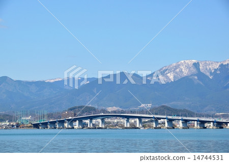 The Lake Biwa Ohashi bridge passing through Biwa lake in early spring and Higarashi Mountain of snow as the background 14744531