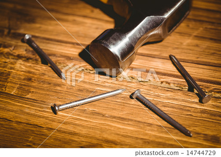 Hammer and nails laid out on table 14744729