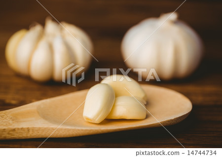 Garlic cloves and bulb on chopping board 14744734