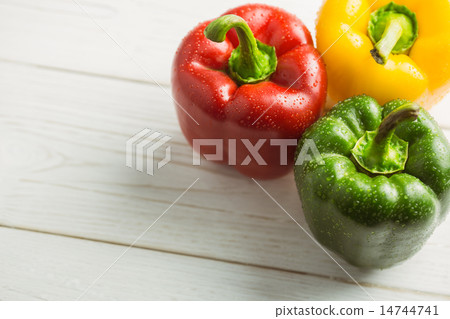 Three peppers on chopping board 14744741