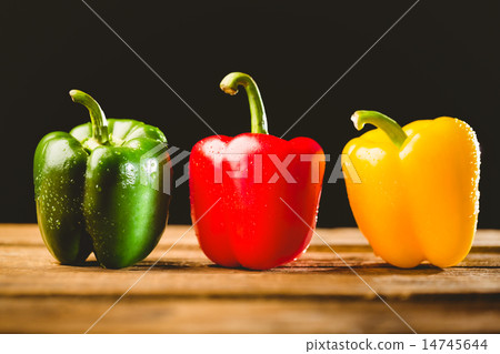 Three peppers on chopping board 14745644
