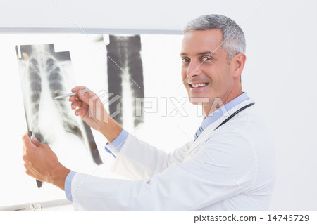 Smiling doctor looking at X-Rays 14745729
