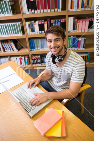 Student studying in the library with laptop 14745762