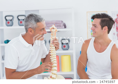 Doctor showing anatomical spine to his patient 14745897