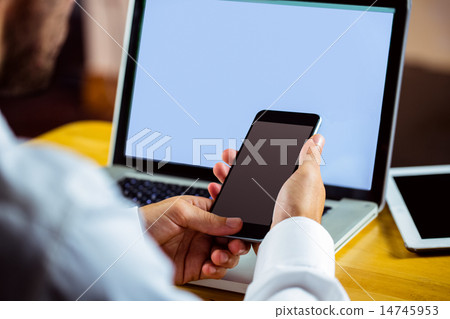Man using laptop and smartphone Man using laptop and smartphone 14745953