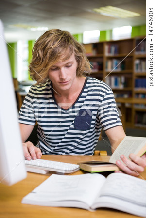 Student studying in the library with computer 14746003